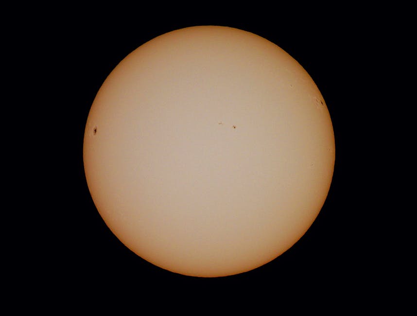 Detailed image of the sun showcasing visible sunspots against a dark background.